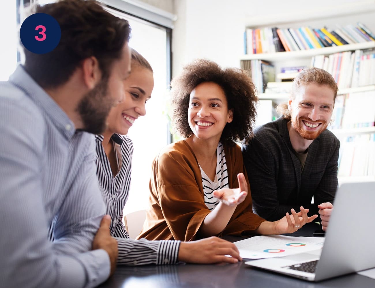 Four colleagues smile while working together on a shared laptop at a desk #Clue: you discovered the letter K! Now find image 7