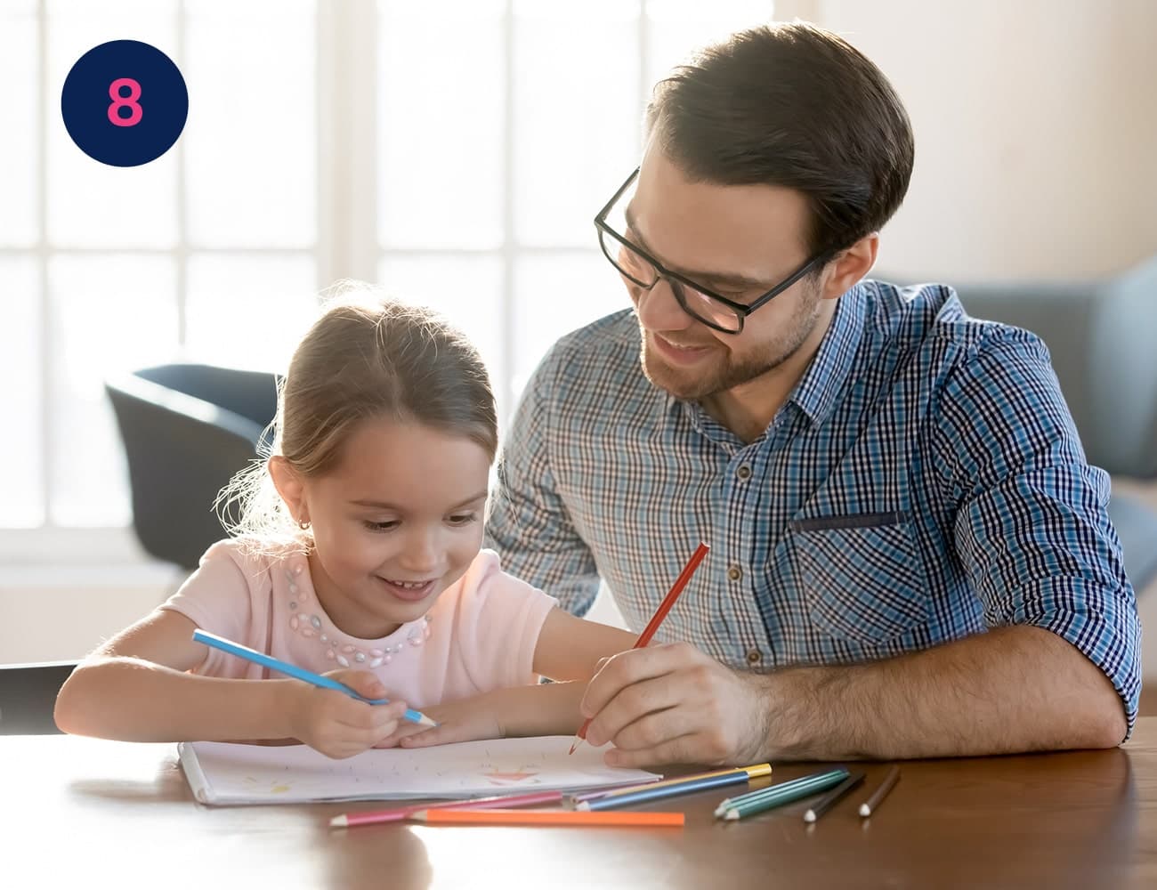 A smiling father and daughter sit at a desk together drawing on paper #Clue: your final hidden letter derives from the Ancient Greek letter alpha. Found your furry friend yet?